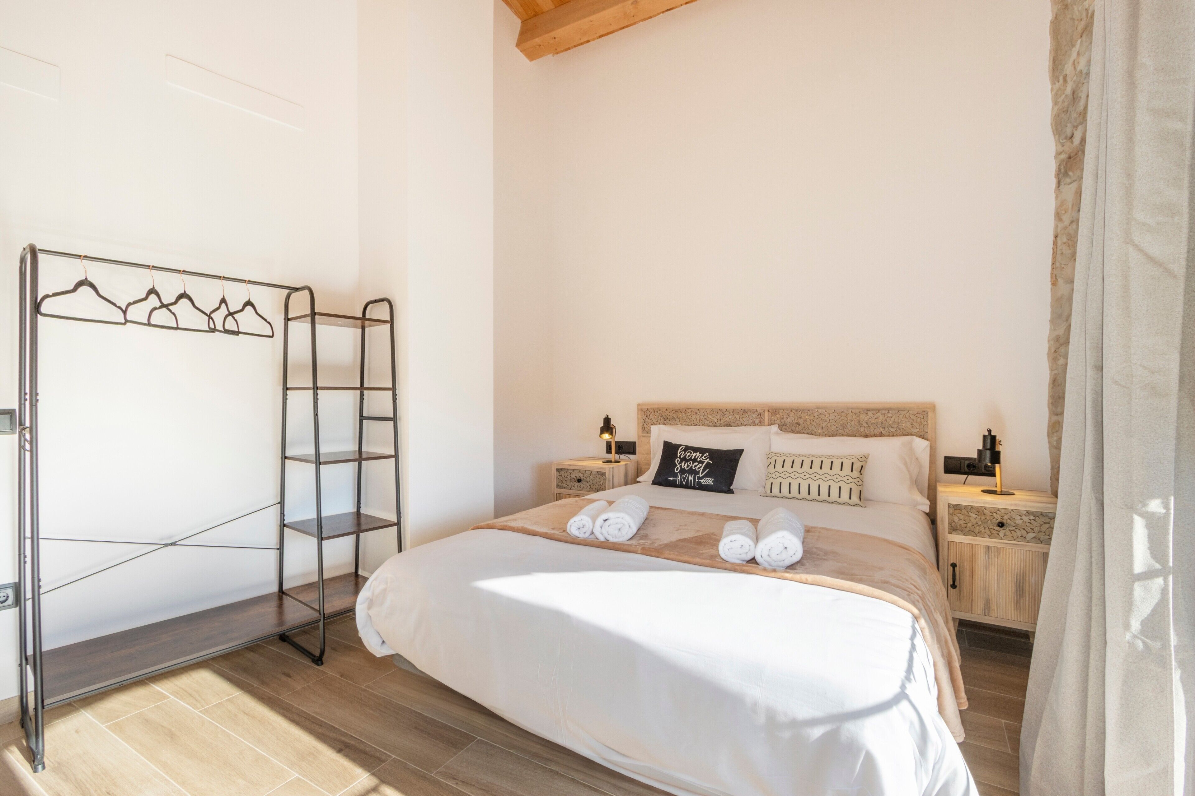 Une chambre à coucher comprenant un lit, une armoire en métal, une table de chevet et une commode.