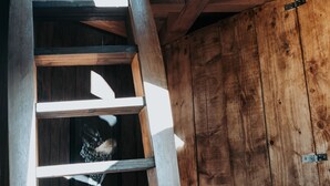 A wooden spiral staircase with a rustic interior, leading to an upper level. - Le Nid du Coucou (Cocumont)