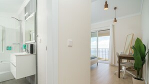 A modern bathroom with a large mirror, white vanity, and a shower. - Madeiran Vernacular Villa • Sunset Views • Garden • Heating (Ponta do Pargo)