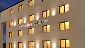 A multi-story hotel with a modern facade, featuring a prominent logo and signage. - Albergo Conte Max (Capracotta)