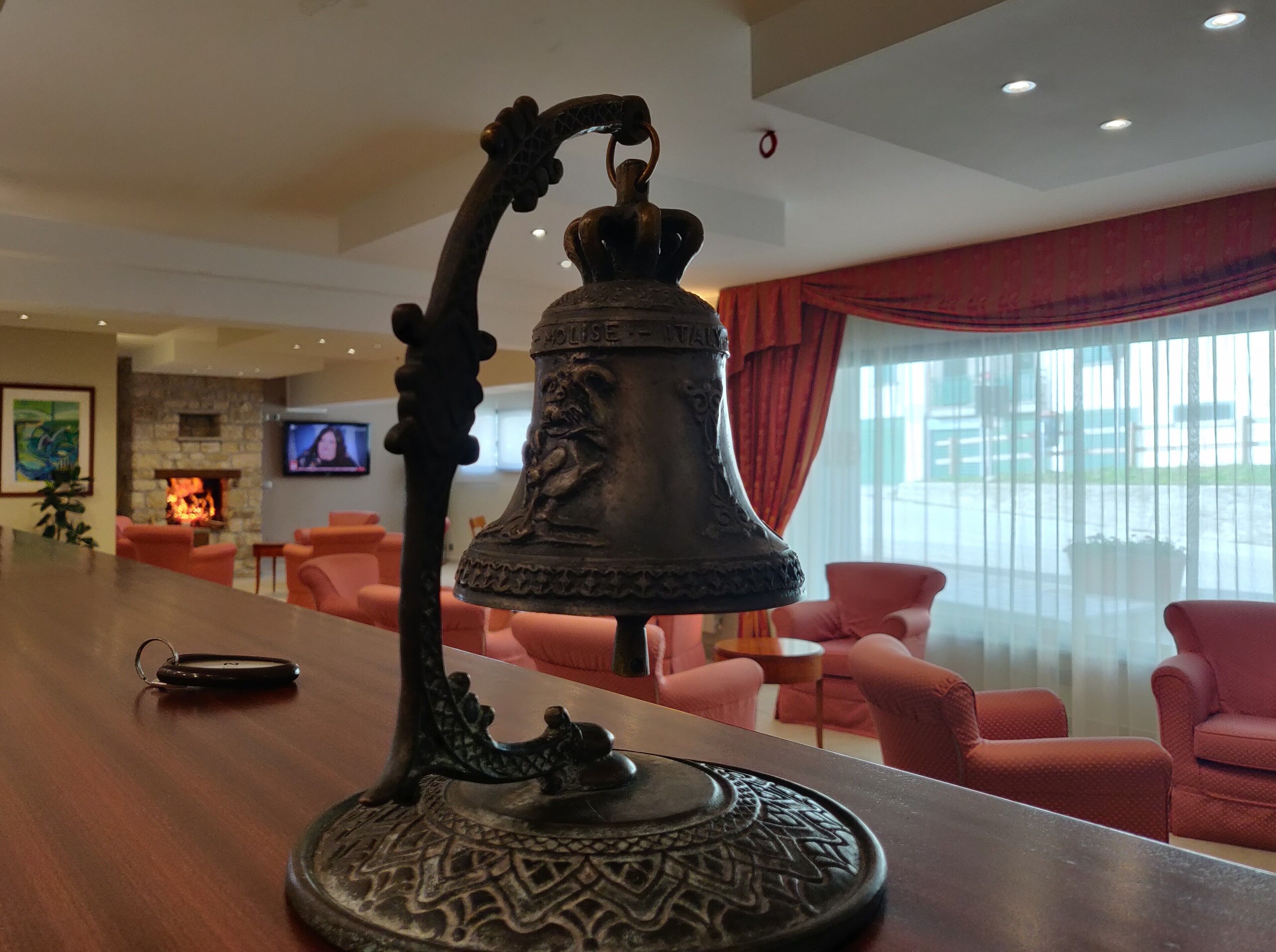 Una hall con area bar, posti a sedere, camino e televisore.