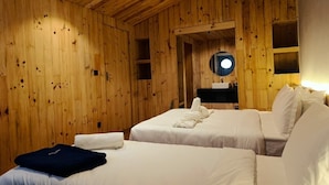 A wooden-paneled room with two beds, a mirror, and a sink. - The Himalayan Phakding (Phakding)