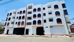 A multi-story building with a white facade and red accents. It features multiple balconies and large windows. - Comfort in the heart of downtown Tacna (Tacna)