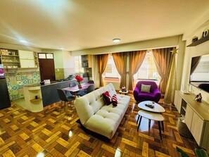 A living room with a sofa, a coffee table, and a dining area with a table and chairs. - Comfort in the heart of downtown Tacna (Tacna)