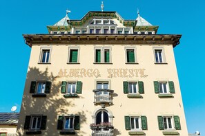 Ein Gebäude mit der Aufschrift 'ALBERGO PRISTI' und einem Balkon mit Blumen.