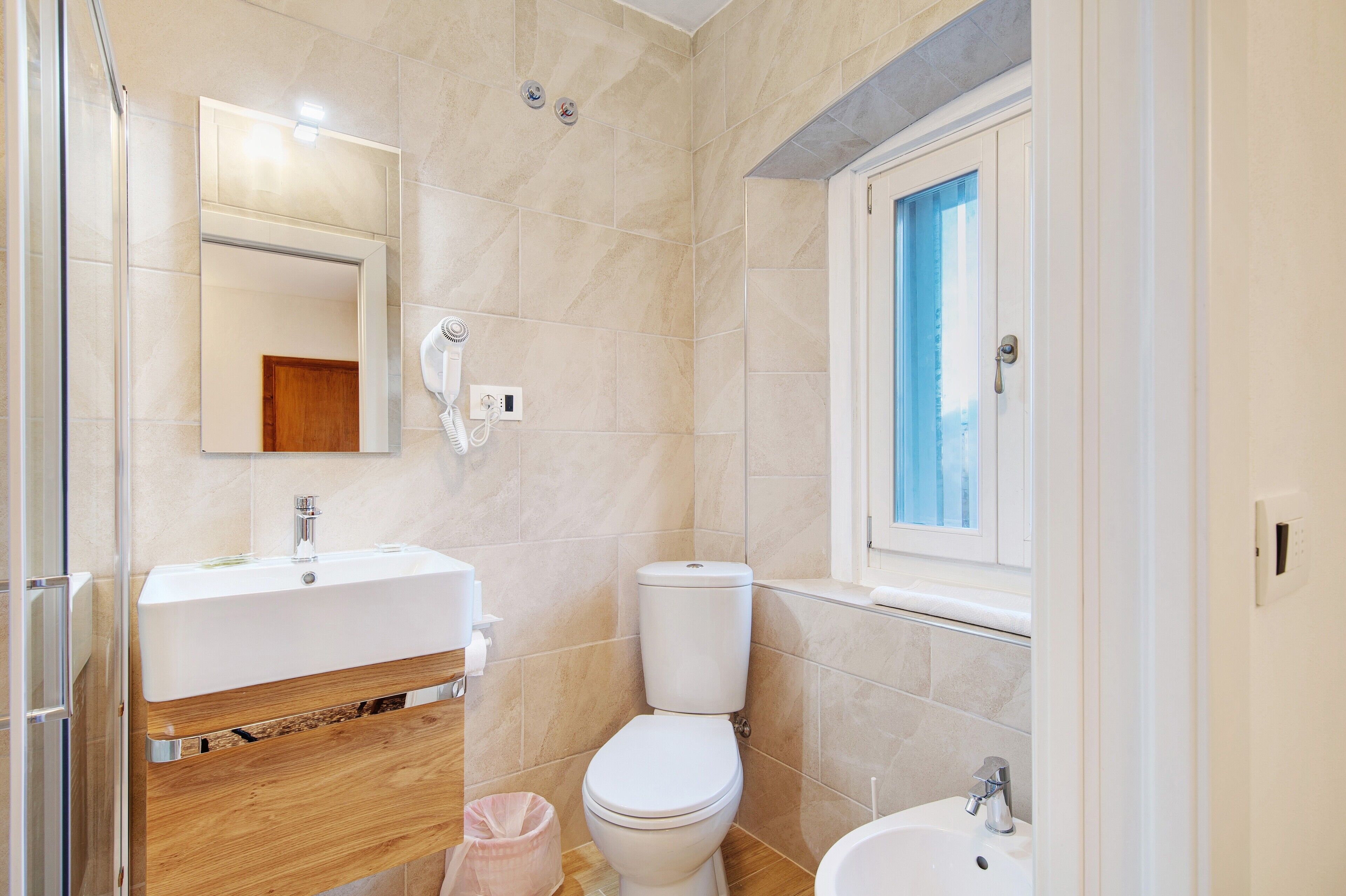 A bathroom with a sink, toilet, and bidet.