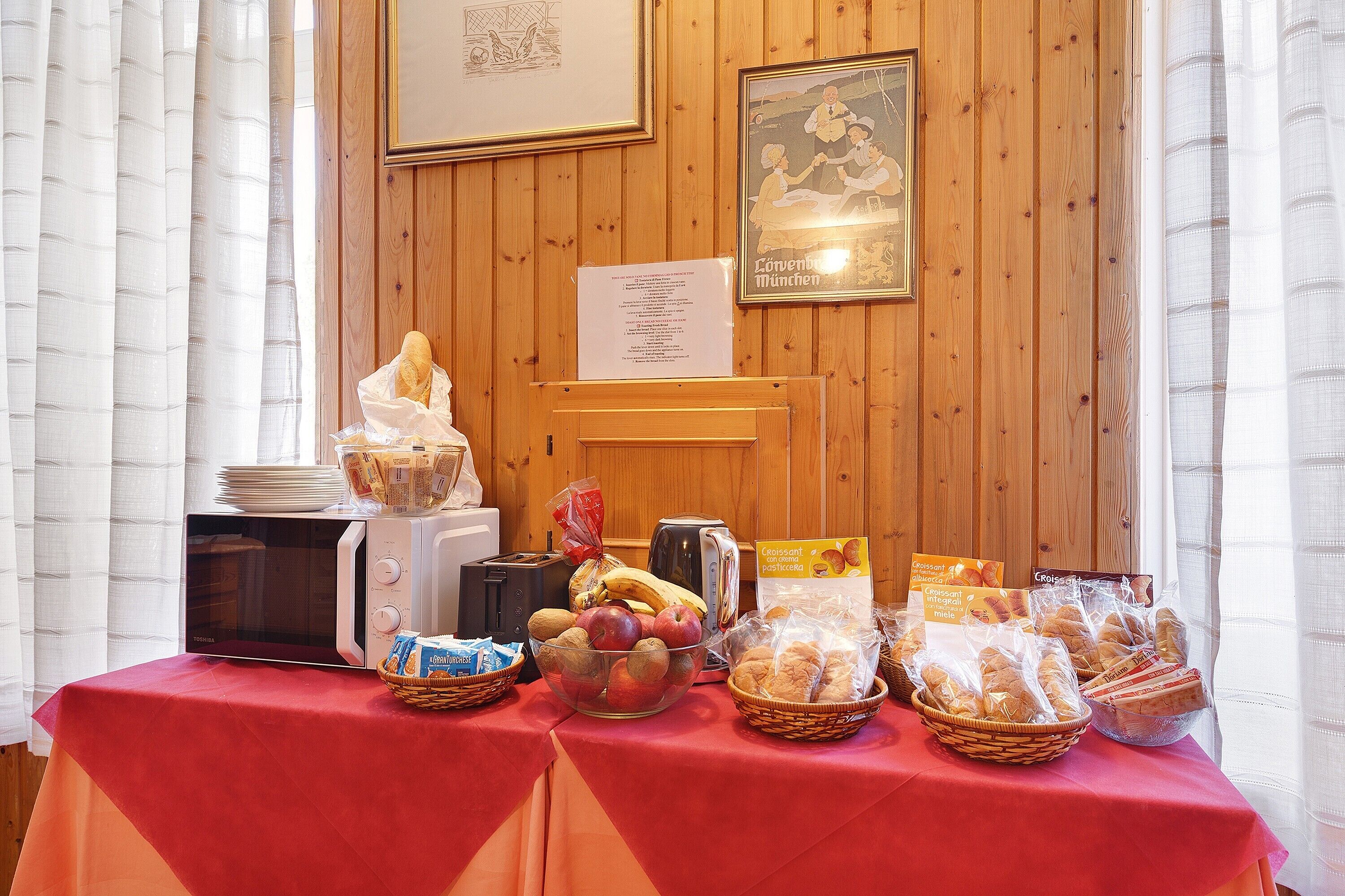 Un buffet della colazione con diversi cibi e un forno a microonde su un tavolo.