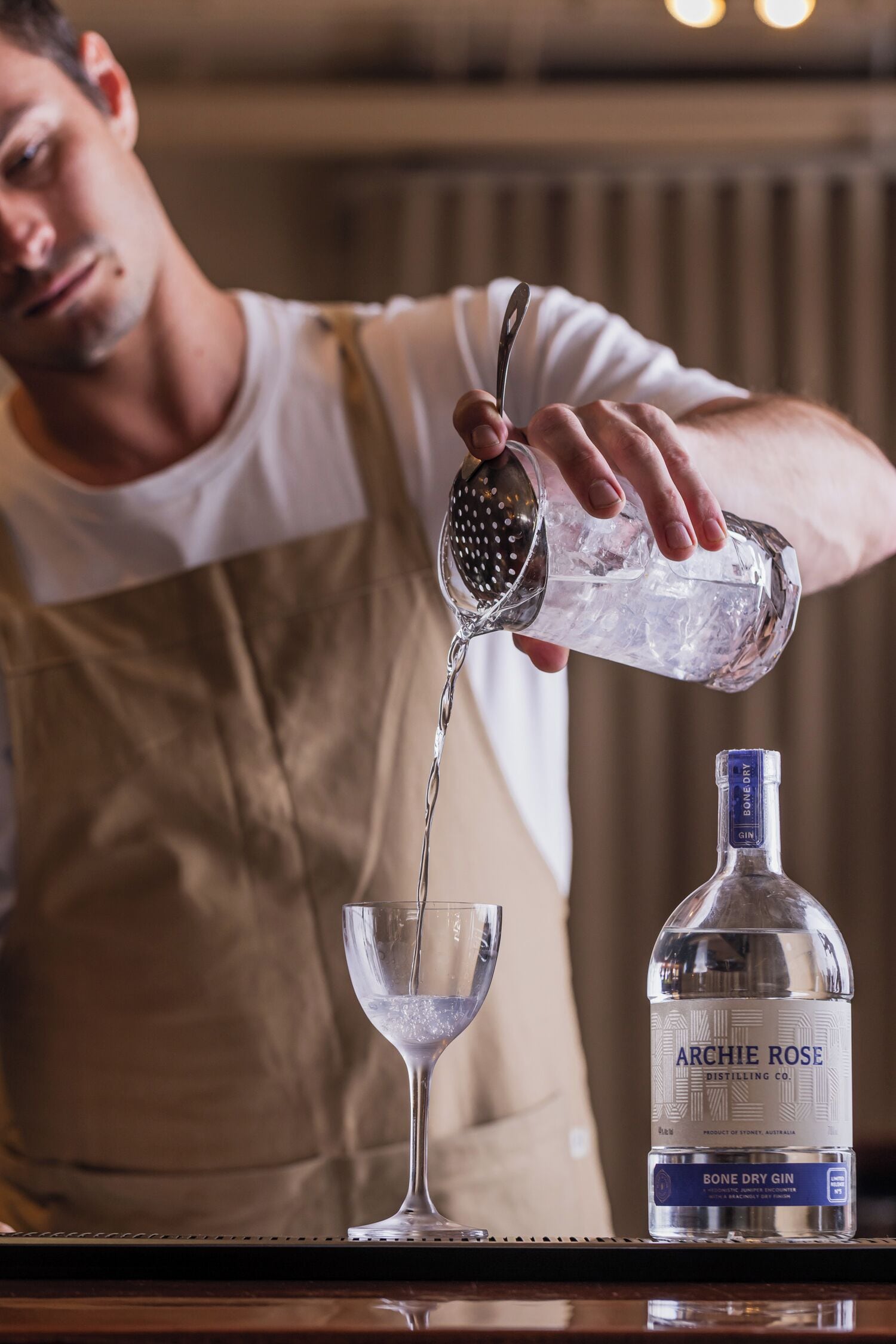 Una persona vertiendo un líquido transparente de una botella en un vaso.