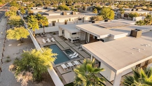 A modern resort with multiple buildings, a swimming pool, and palm trees. - Oxygen @ Elemento49 - Pool & Spa - Sleeps 16 (Indio)
