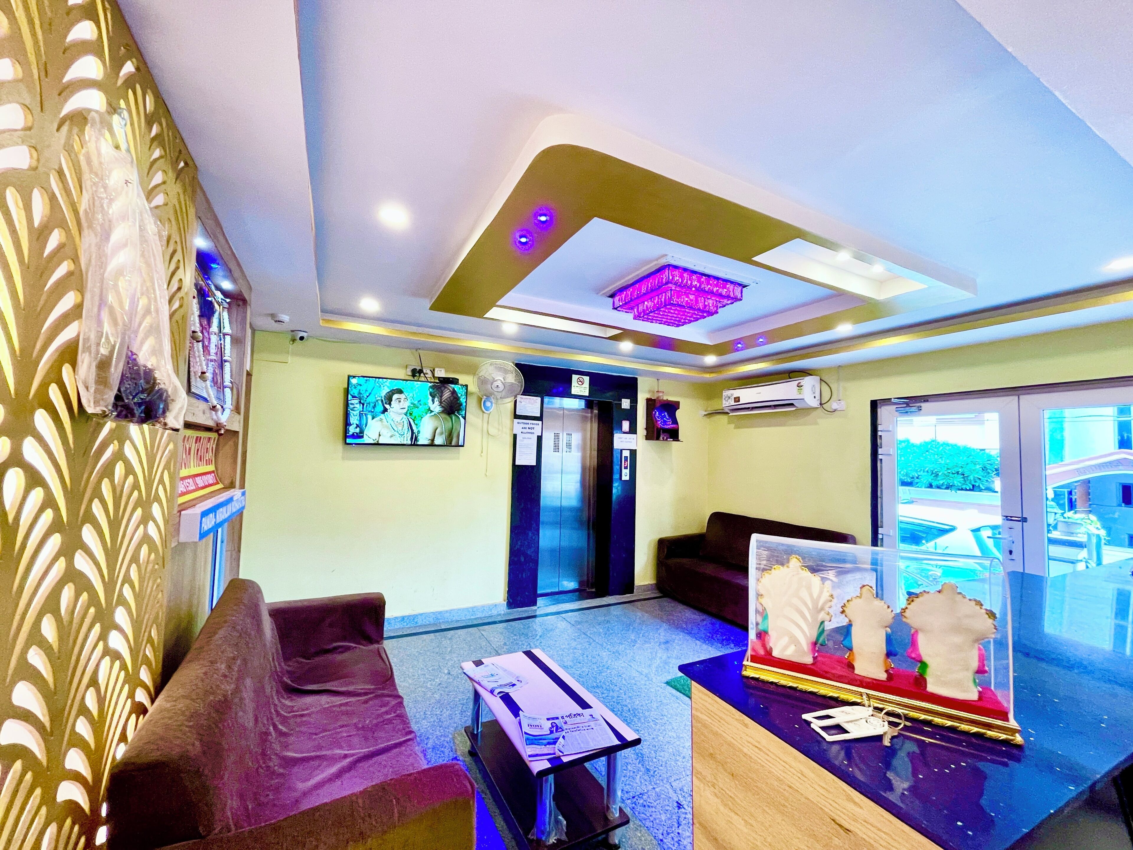 A reception area with a TV, seating, a reception desk, and a decorative display.