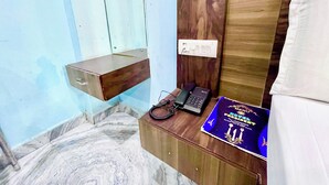 A hotel room with a wooden nightstand, a telephone, and a menu board. - Hotel President Inn -near Temple & Beach (Puri)
