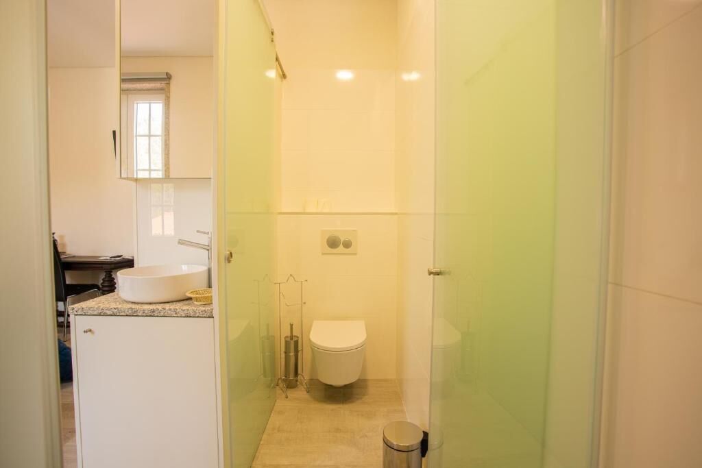 A compact bathroom with a toilet, sink, and shower area.
