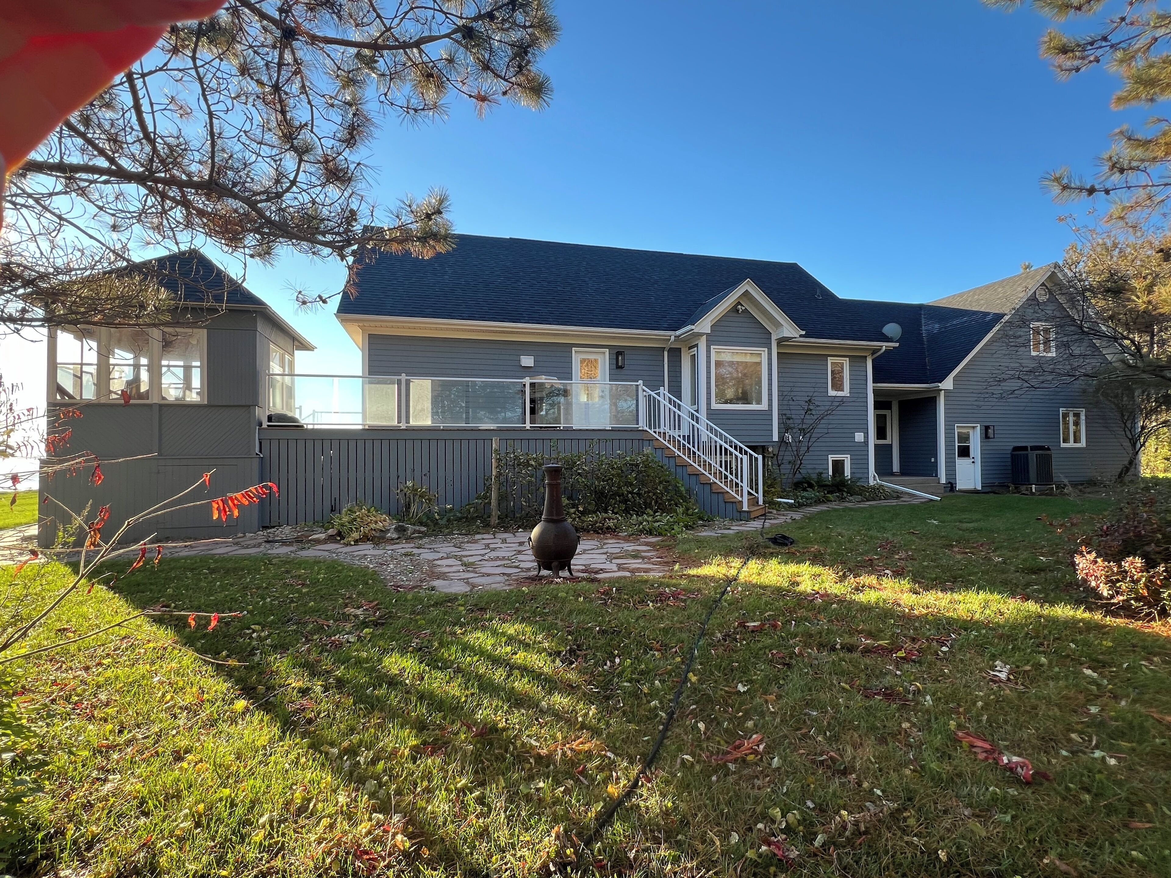 A two-story house with a covered patio, a large vase, and a well-maintained lawn.
