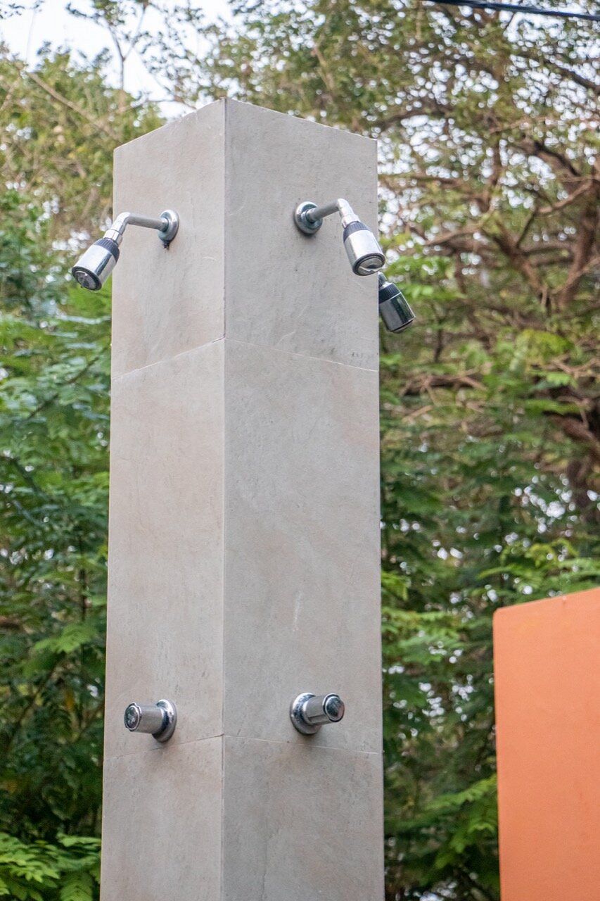 Een hoge, rechthoekige stenen constructie met vier metalen bevestigingen, waarschijnlijk voor water of lucht.