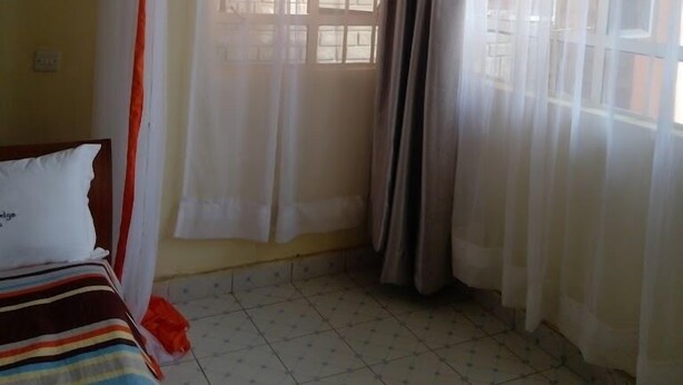 Una stanza con un letto, tende e una finestra.