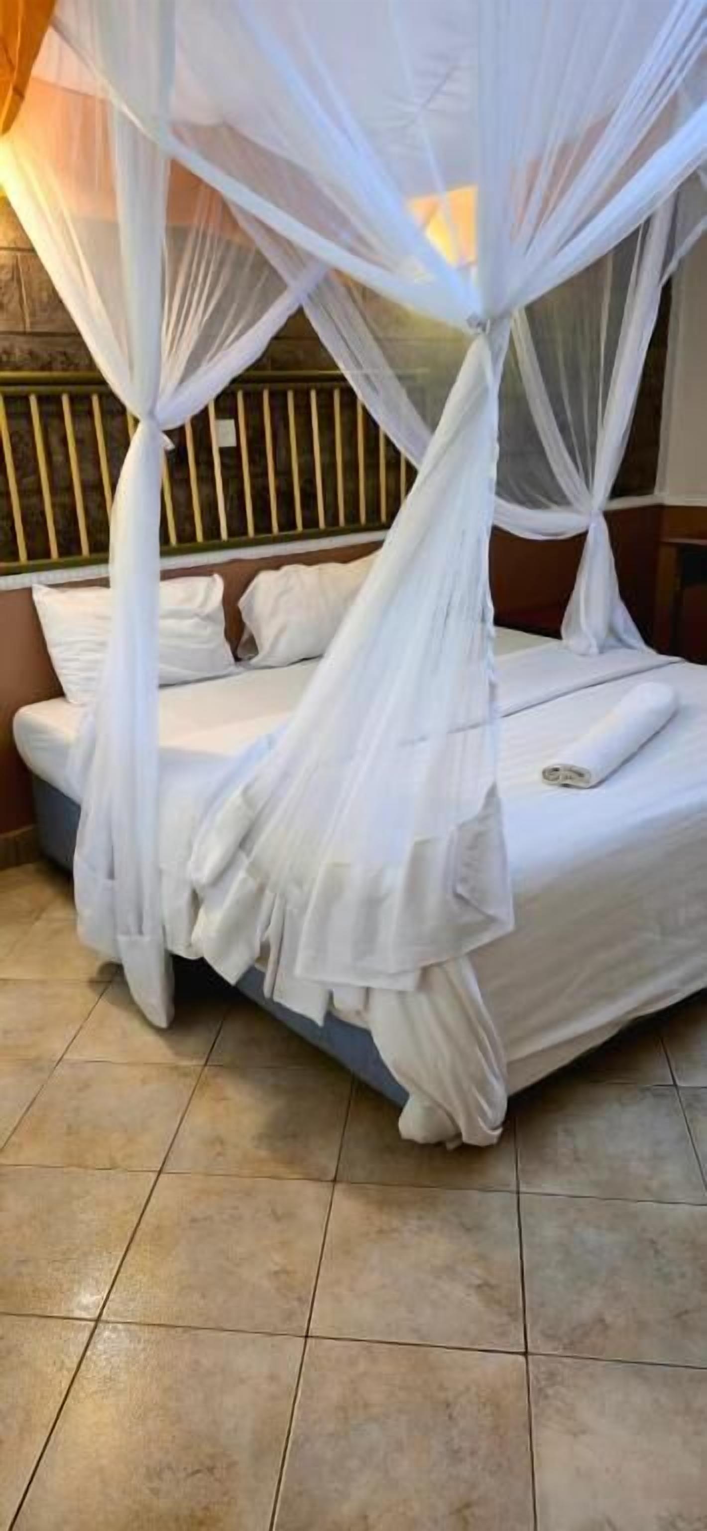 A bed with a white canopy and a wooden headboard.