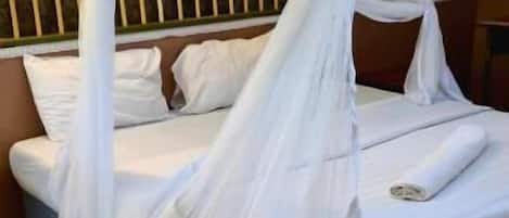 A bed with a white canopy and a wooden headboard.