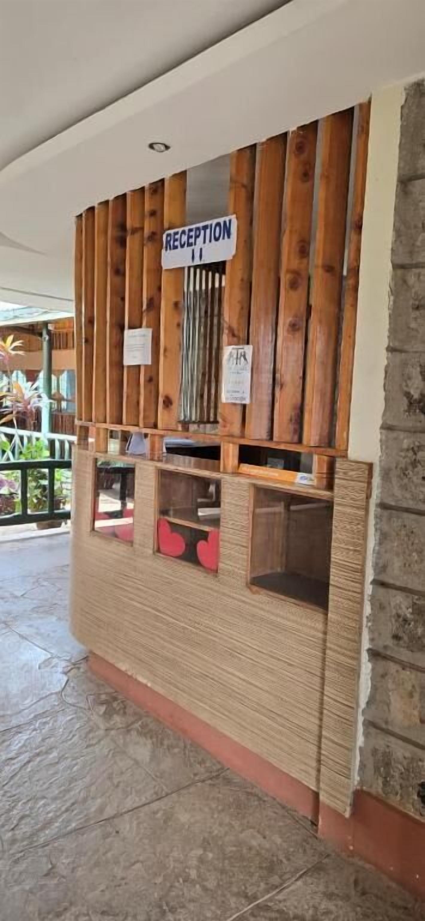 A reception desk with a wooden panel design and a sign that reads "RECEPTION".