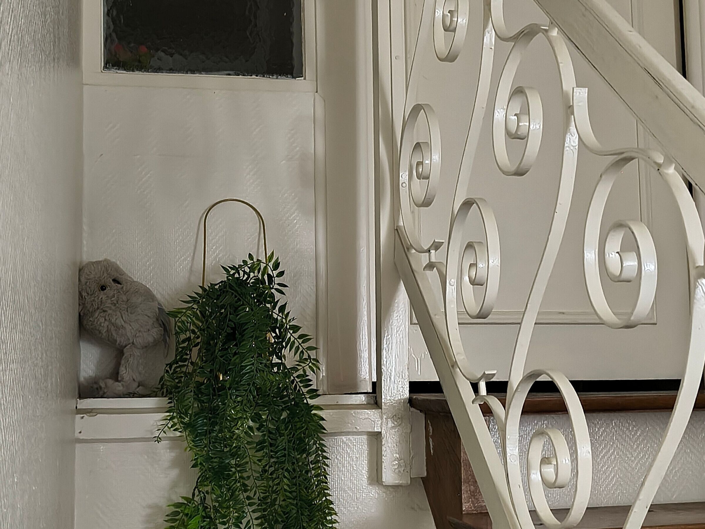Un escalier avec des rampes blanches et un motif décoratif en métal.