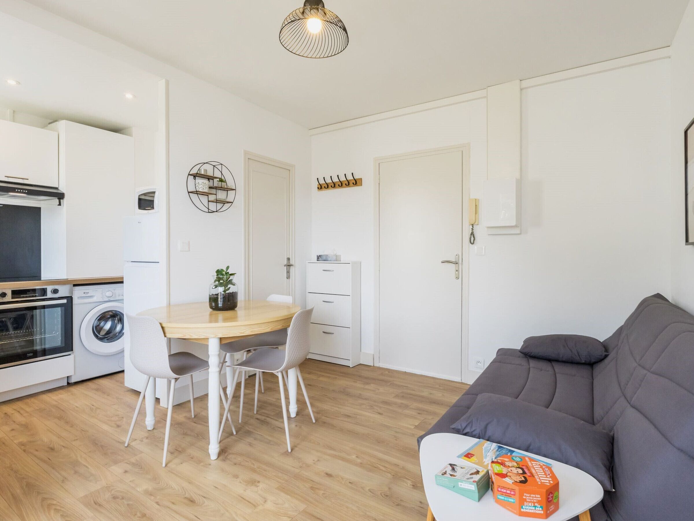 Un espacio habitable compacto con kitchenette, comedor y zona de estar.