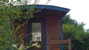 A wooden cabin with a door and a small porch. - Unique Caravan with Private Nordic Bath in La Flèche (La Flèche)