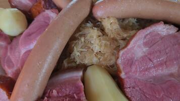 Une variété de viandes, notamment des saucisses, du jambon et, éventuellement, du lard, servies dans une assiette.