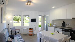 A compact living space with a kitchenette, a dining area, and a sofa. - Renovated apartment 50m from Grifeu Beach (Llançà)