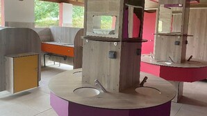 Une salle de bain moderne avec un lavabo central, un miroir et une structure en bois.
