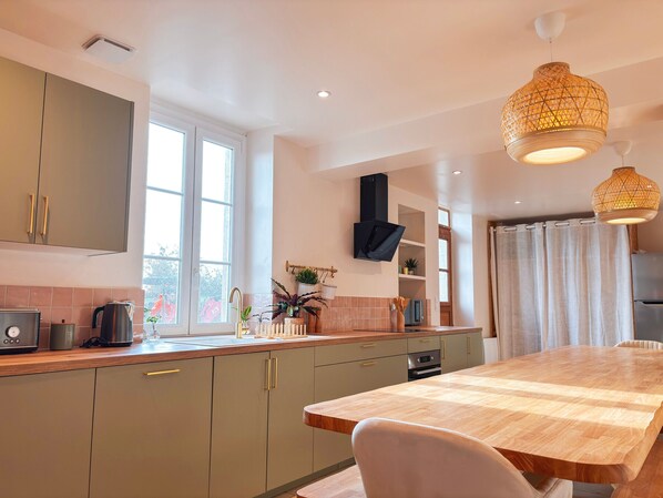 A modern kitchen with a wooden island, built-in cabinets, and pendant lighting.