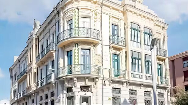 Un edificio histórico con arquitectura clásica, que destaca por una cúpula imponente y balcones ornamentados.