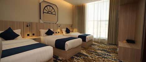 Habitación triple junior, vista a la ciudad | Caja de seguridad en la habitación y cortinas blackout