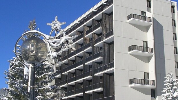 Un edificio moderno con varios balcones y un letrero que dice 'ANDROMEDES'.