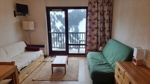Una sala de estar acogedora con un sofá, una mesa de madera y un sofá verde.