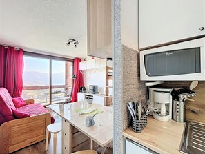 A compact living space with a kitchenette, a dining area, and a sofa. - Renovated studio ski-in/ski-out, balcony mountain view, free wifi, 4 guests (Le Corbier)
