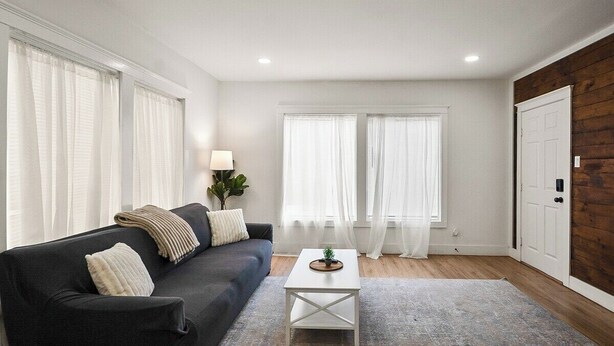 Ein Wohnzimmer mit einer Couch, einem Couchtisch und einer Tür.