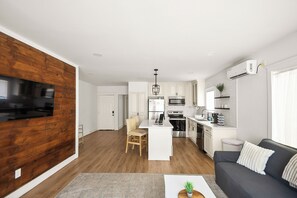 A modern kitchen with white cabinets, stainless steel appliances, and a central island.