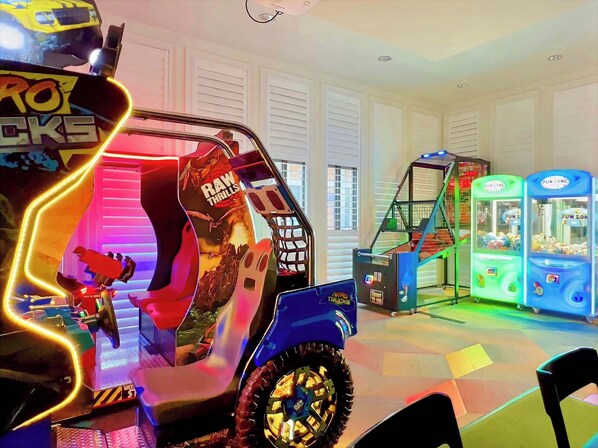A children's play area with a large, colorful ride-on vehicle and claw machines.