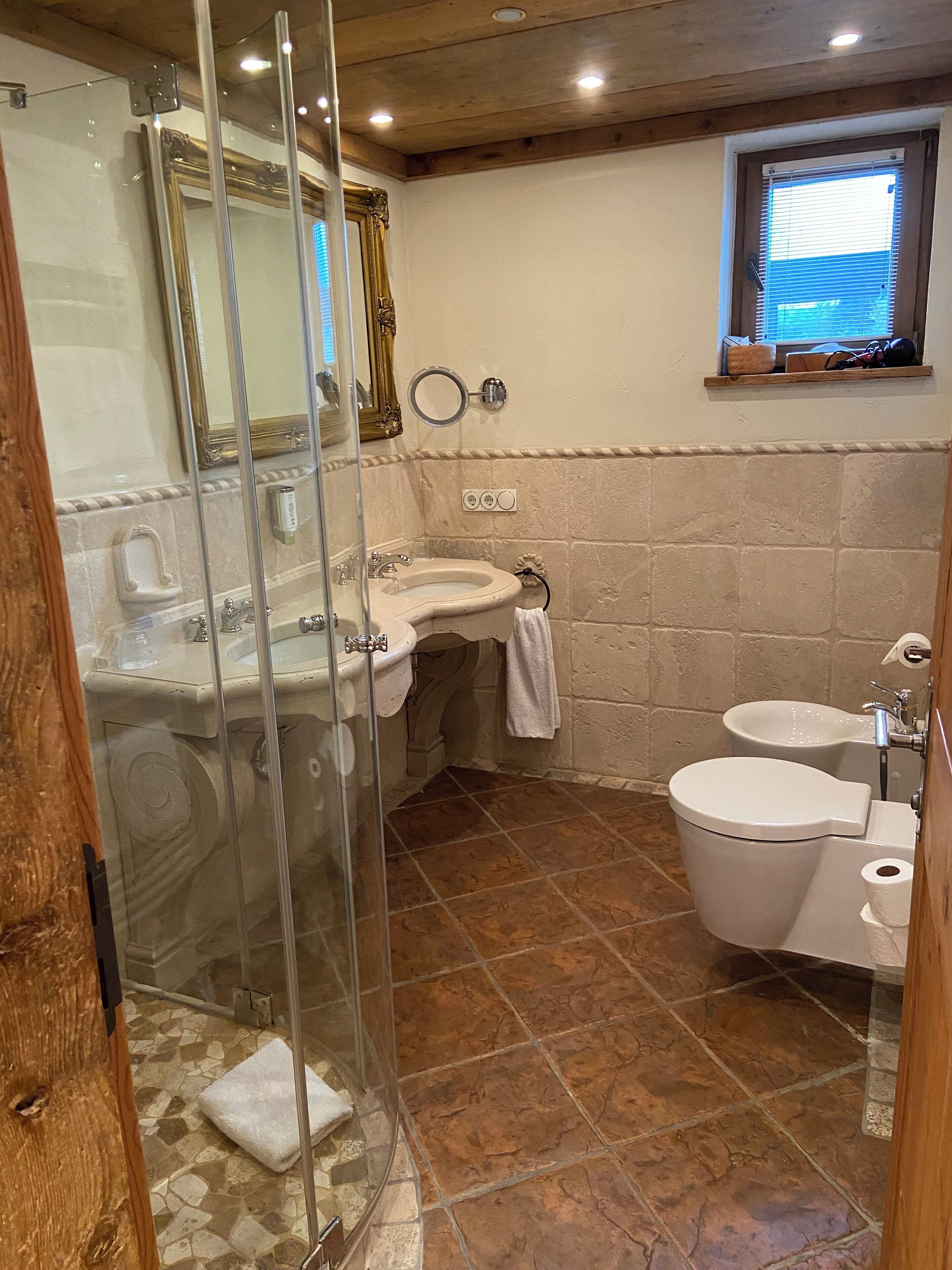 Une salle de bain avec une douche à parois de verre, un lavabo, des toilettes et un bidet.
