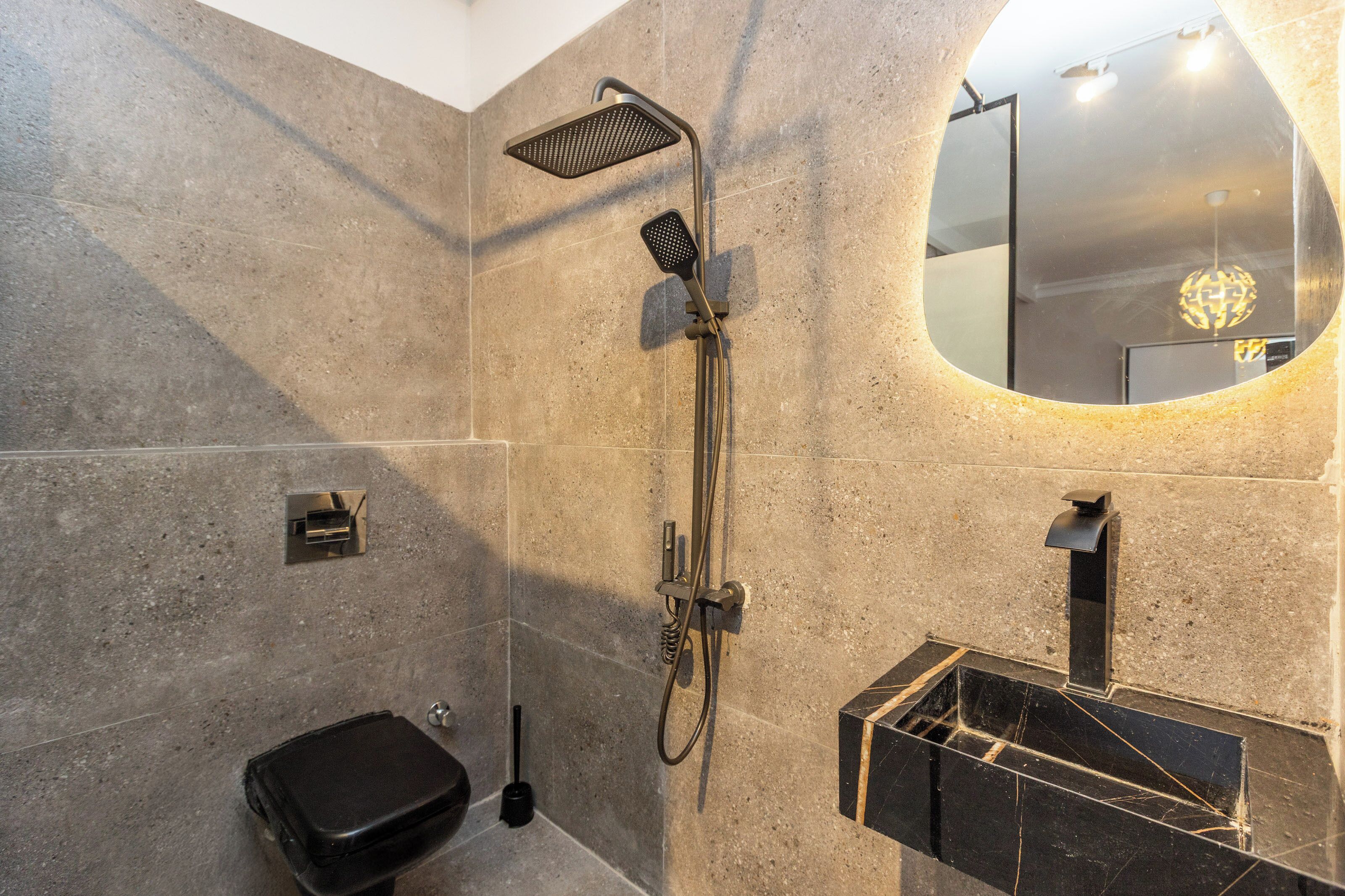 Un bagno moderno con doccia, WC e lavandino.
