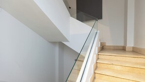 Una escalera moderna con barandillas de vidrio y escalones de madera.
