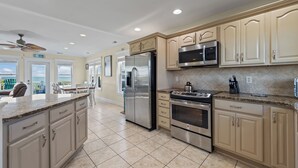 A spacious kitchen with beige cabinetry, stainless steel appliances, and a granite countertop. - Summer Days Cooler Nights #201 - 2nd Row Dog-Friendly House in Topsail Beach! (Topsail Beach)