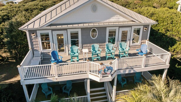 A large house with a balcony, multiple windows, and outdoor seating. - Summer Days Cooler Nights #201 - 2nd Row Dog-Friendly House in Topsail Beach! (Topsail Beach)