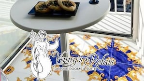 A balcony with a table, a bottle of wine, and a glass. - Vinny's Relais - Deluxe rooms & Suite (Vietri sul Mare)