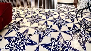 Ett kök med ett kaklat golv med ett geometriskt mönster, en randig vägg och en modern design.