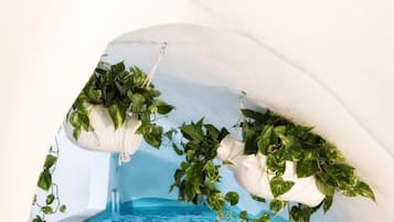 Area piscina con fioriere sospese e logo del Vinny's Relais Deluxe Rooms & Suite.