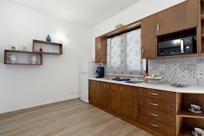 Una cocina con armarios de madera, un microondas y un refrigerador.