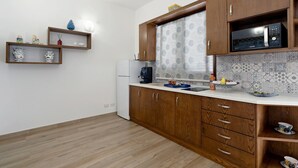 Une cuisine avec des meubles de rangement en bois, un four à micro-ondes et un réfrigérateur.