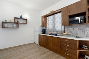 A kitchen with wooden cabinets, a microwave, and a refrigerator.