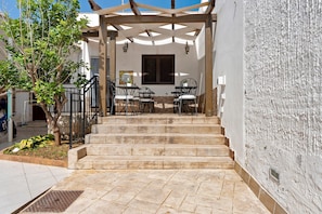 A covered outdoor seating area with steps leading up to a building entrance. - Room 'La Rocca 4' with Private Terrace, Wi-Fi and Air Conditioning (San Vito Lo Capo)