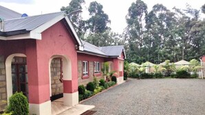 A red building with a gravel driveway and a small garden area. - Good Morning Hotel Rongo (Rongo)